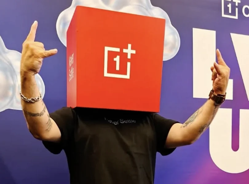 OnePlus community member in a red OnePlus box head throwing rock horns at a pop-up