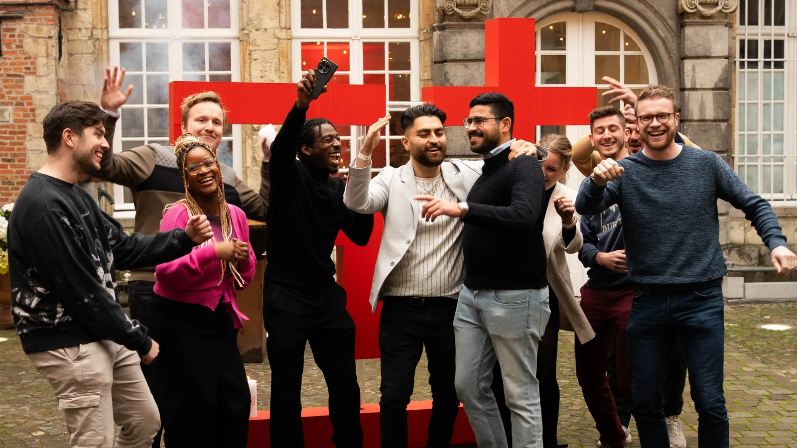 Community members celebrating in front of a giant red OnePlus logo